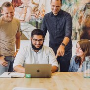 Group of people around a laptop