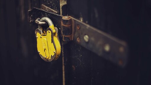 A yellow padlock securing a door