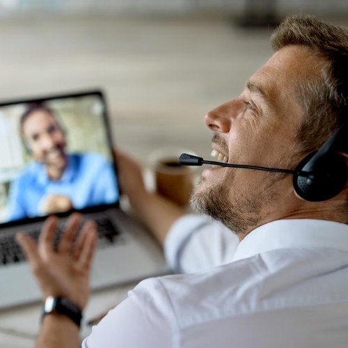 Cheerful man wearing a headset on a video call