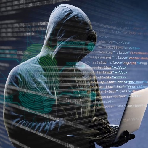 Sneaky looking hacker wearing a hoodie using a laptop, probably for nefarious deeds